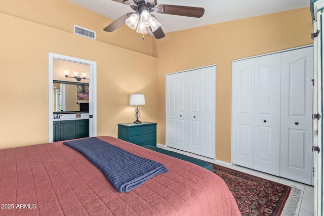 tiled bedroom with a ceiling fan, visible vents, and multiple closets