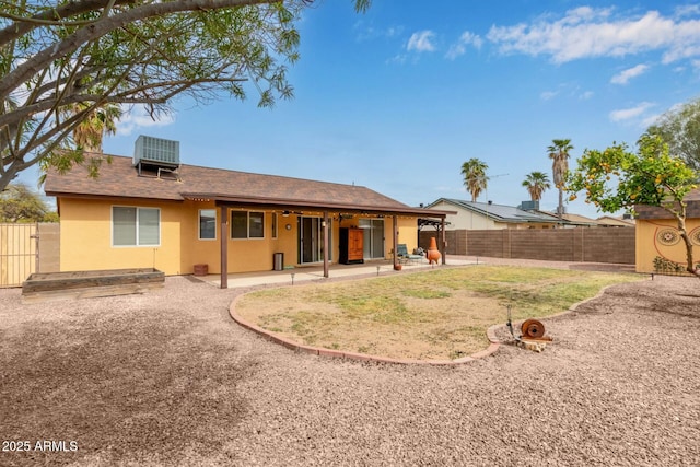 back of property with a patio, central air condition unit, a fenced backyard, and stucco siding