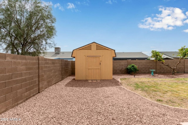 view of yard with an outbuilding, a fenced backyard, and a storage unit