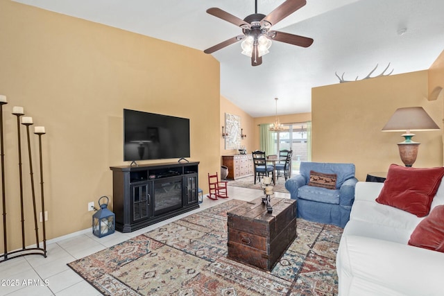 living area featuring lofted ceiling, tile patterned flooring, ceiling fan with notable chandelier, baseboards, and a glass covered fireplace