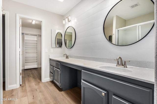 bathroom featuring walk in shower, vanity, and hardwood / wood-style floors