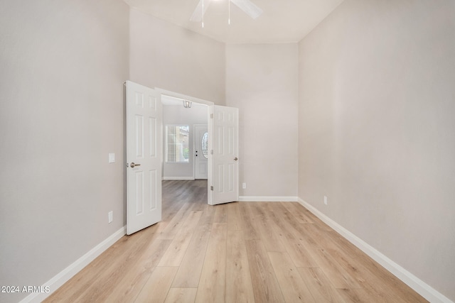 empty room with ceiling fan and light hardwood / wood-style floors