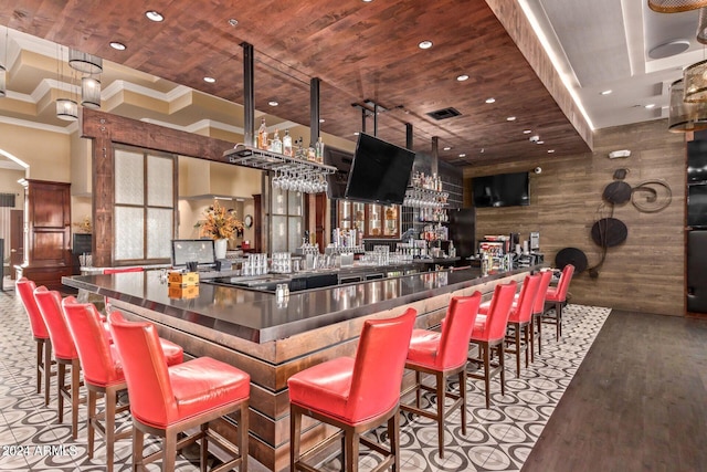 bar featuring hardwood / wood-style flooring, wood ceiling, crown molding, and wood walls