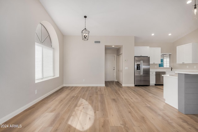 kitchen with light hardwood / wood-style floors, pendant lighting, a notable chandelier, white cabinets, and appliances with stainless steel finishes