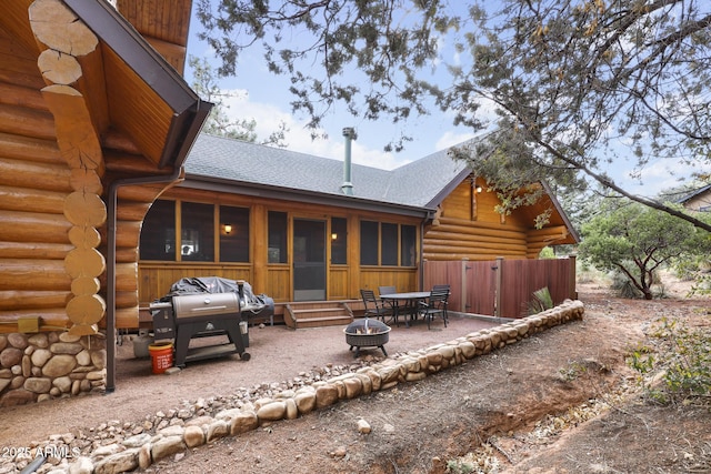 rear view of house with an outdoor fire pit, a sunroom, and a patio area