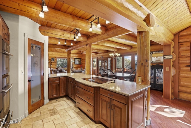 kitchen with wood ceiling, a notable chandelier, light stone countertops, black electric cooktop, and kitchen peninsula