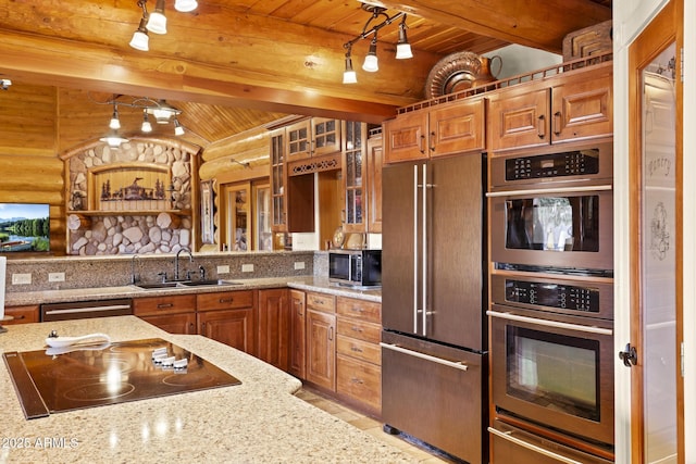 kitchen featuring light stone countertops, log walls, wooden ceiling, and appliances with stainless steel finishes