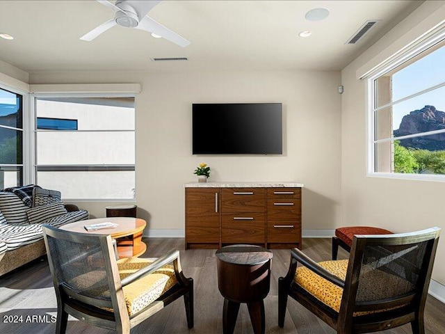 living room with ceiling fan and dark wood-type flooring