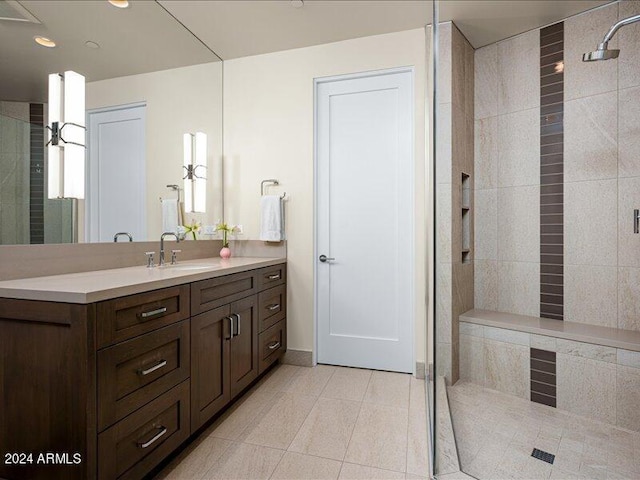 bathroom with tile flooring, vanity, and a shower with door