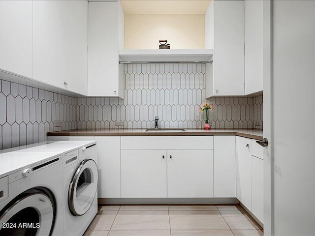 washroom with washer and clothes dryer, cabinets, sink, and light tile flooring