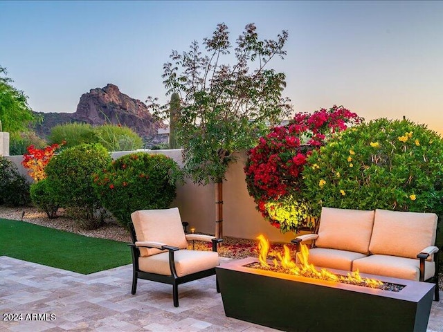 patio terrace at dusk with a mountain view and an outdoor living space with a fire pit