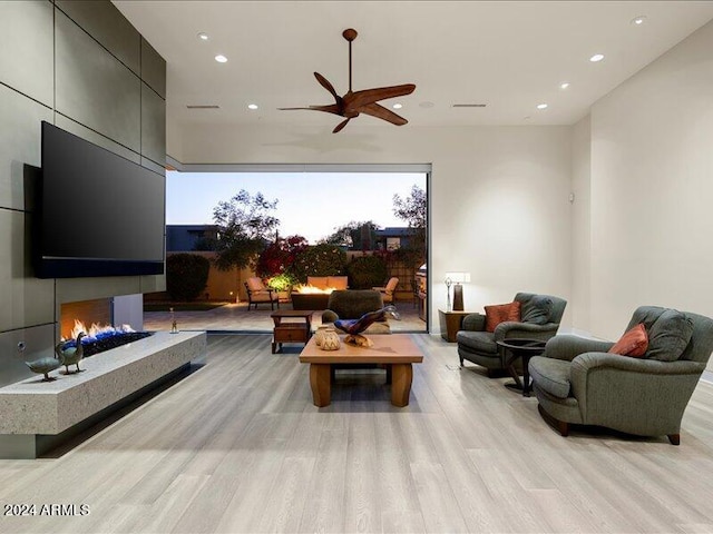 living room with light hardwood / wood-style flooring and ceiling fan