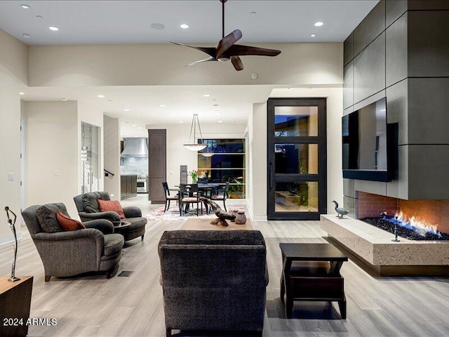 living room with light hardwood / wood-style flooring and ceiling fan