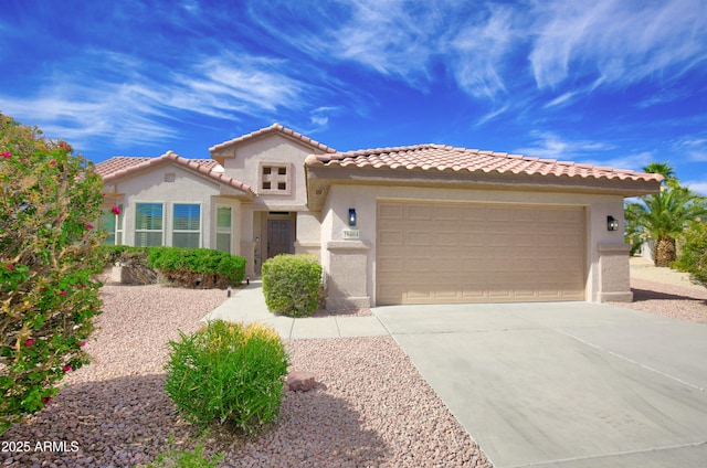 mediterranean / spanish-style home featuring driveway, a tiled roof, a garage, and stucco siding