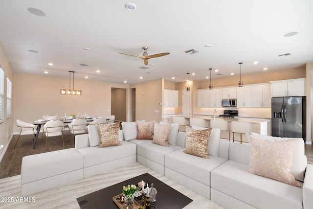 living room with ceiling fan and light hardwood / wood-style floors