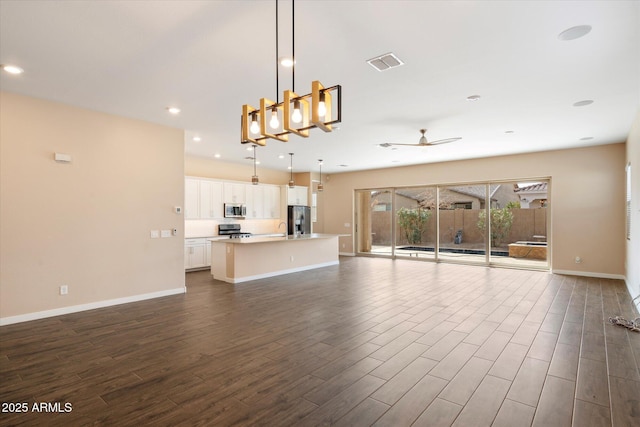 unfurnished living room with dark hardwood / wood-style flooring, sink, and ceiling fan