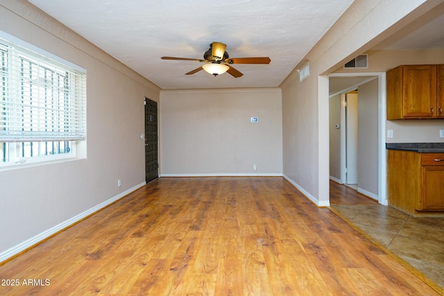 1301 N Santa Rosa Ave, Tucson, AZ 85712 - unfurnished living room featuring visible vents, ceiling fan, and baseboards