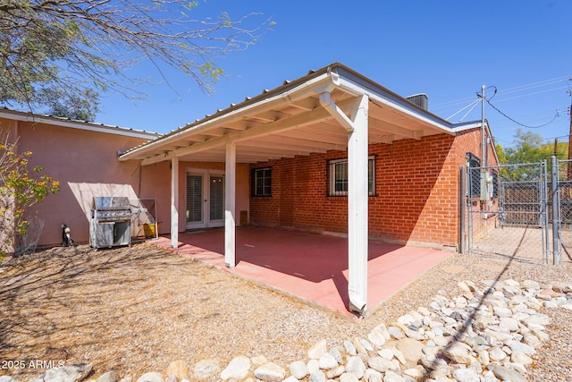 1301 N Santa Rosa Ave, Tucson, AZ 85712 - back of house featuring a gate, french doors, a patio area, brick siding, and fence