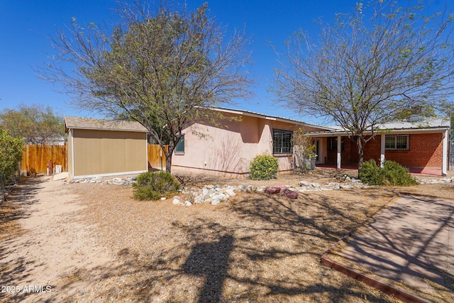 1301 N Santa Rosa Ave, Tucson, AZ 85712 - ranch-style home with stucco siding, an outdoor structure, fence, and covered porch