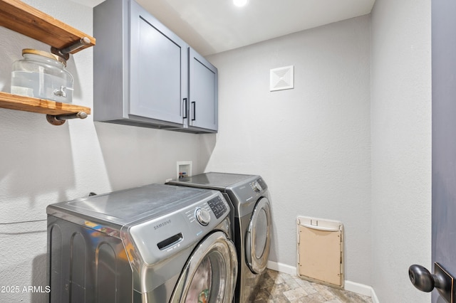 washroom featuring washing machine and dryer and cabinets