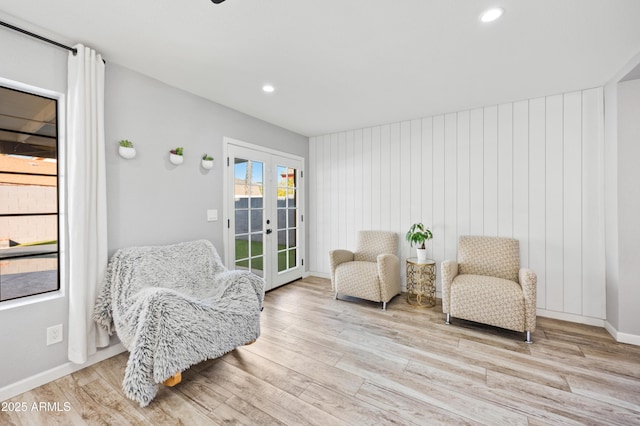 living area with french doors and light hardwood / wood-style floors