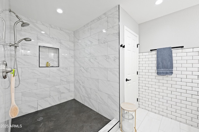 bathroom with a tile shower and tile walls