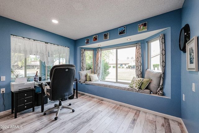 office space with light hardwood / wood-style floors and a textured ceiling