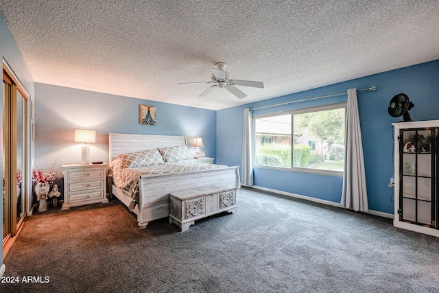 bedroom featuring dark colored carpet, ceiling fan, a textured ceiling, and a closet