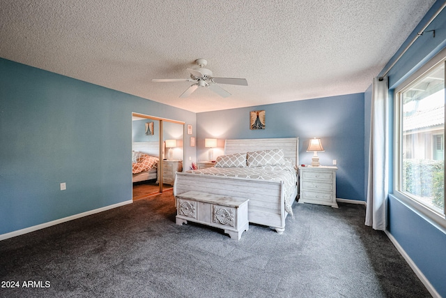 carpeted bedroom with ceiling fan, a closet, and a textured ceiling