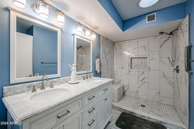 bathroom with vanity and tiled shower