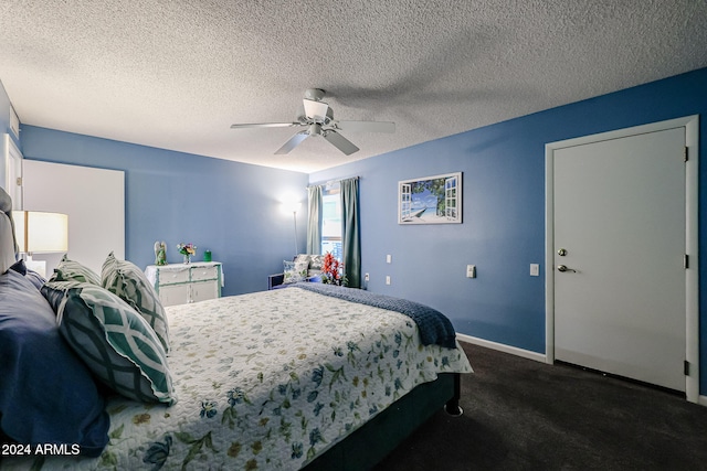 bedroom with ceiling fan, dark carpet, and a textured ceiling