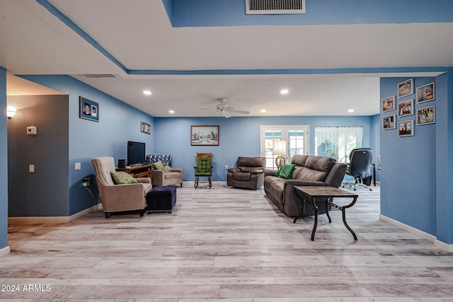 living room with ceiling fan, light hardwood / wood-style flooring, and french doors