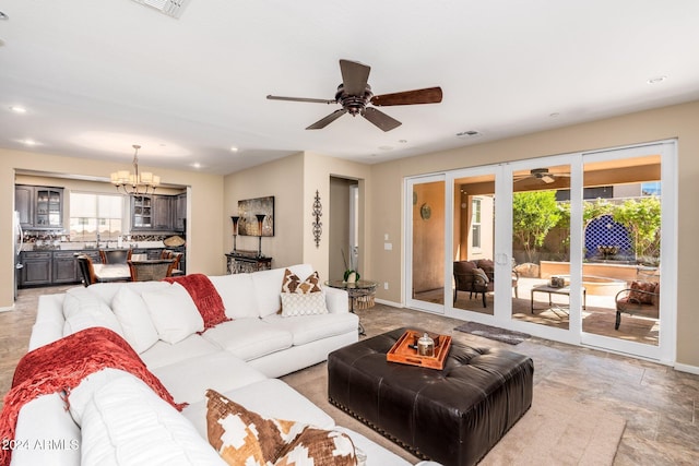 living room featuring plenty of natural light and ceiling fan with notable chandelier