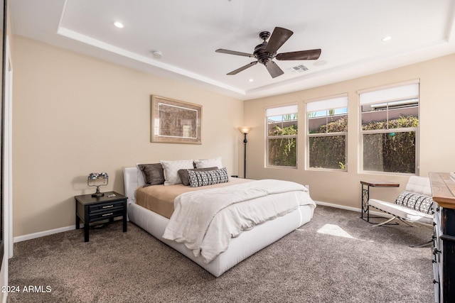 bedroom with carpet floors, a raised ceiling, and ceiling fan