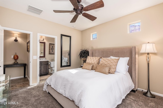 carpeted bedroom featuring ensuite bathroom, ceiling fan, and multiple windows