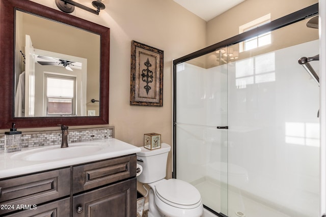 bathroom featuring vanity, ceiling fan, toilet, and a shower with door