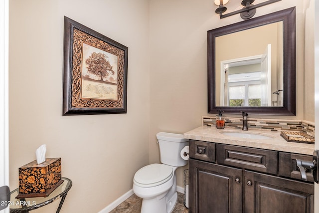 bathroom featuring vanity, toilet, and backsplash