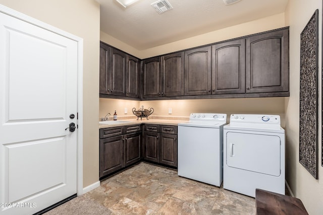 washroom featuring a textured ceiling, cabinets, independent washer and dryer, and sink