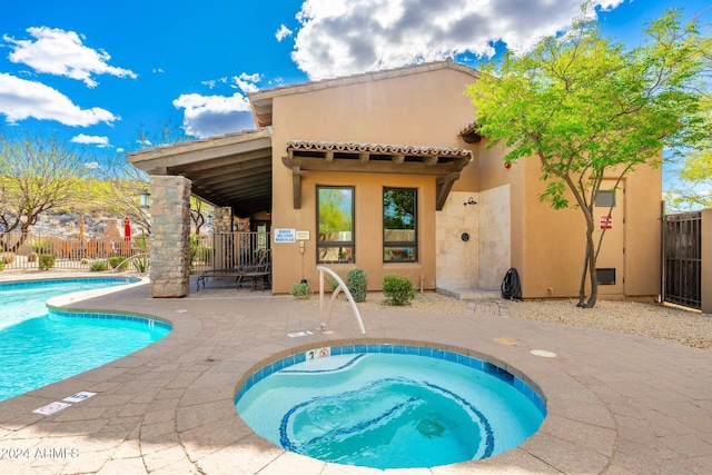 view of swimming pool with a community hot tub and a patio