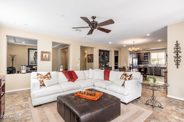 living room with ceiling fan with notable chandelier