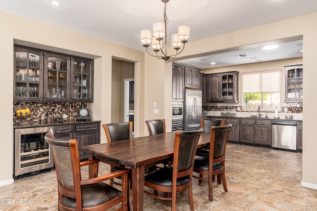 dining space with sink, beverage cooler, and a notable chandelier