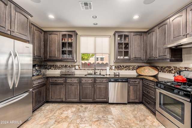 kitchen featuring sink, dark stone counters, dark brown cabinets, and appliances with stainless steel finishes