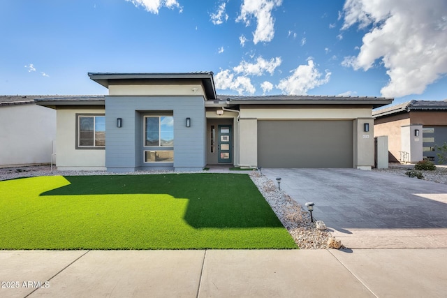 prairie-style home with a garage, stucco siding, decorative driveway, and a front yard