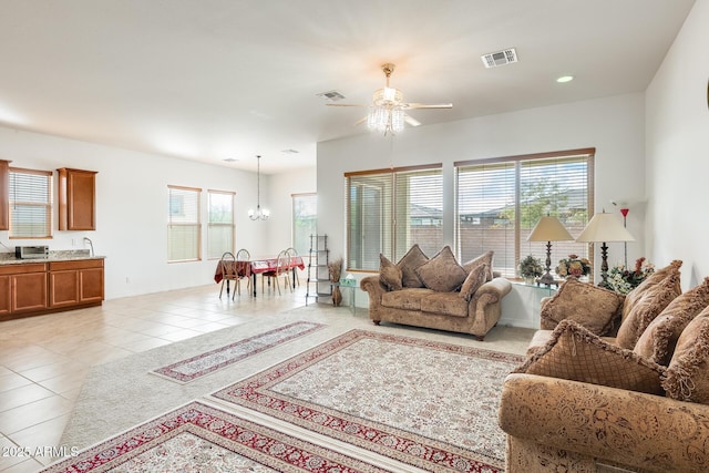 living area featuring recessed lighting, ceiling fan with notable chandelier, visible vents, and light tile patterned flooring