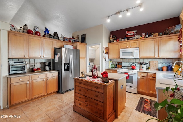 kitchen with sink, tasteful backsplash, vaulted ceiling, light tile patterned floors, and white appliances