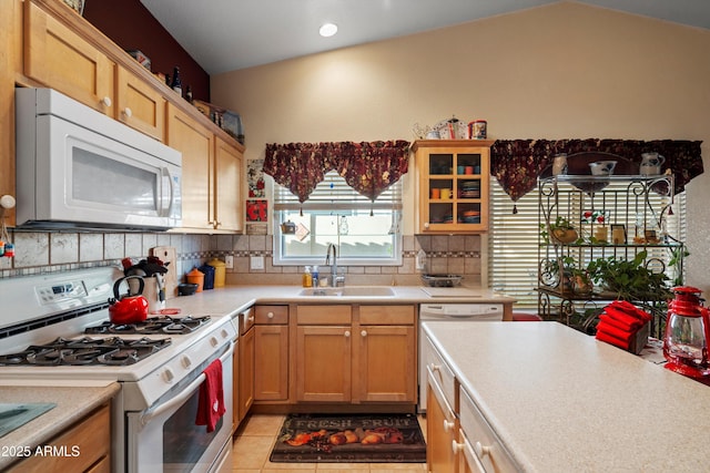 kitchen with lofted ceiling, sink, white appliances, tasteful backsplash, and light tile patterned flooring