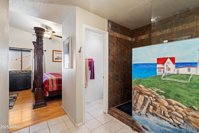 bathroom with a tile shower, ceiling fan, tile patterned floors, and a textured ceiling