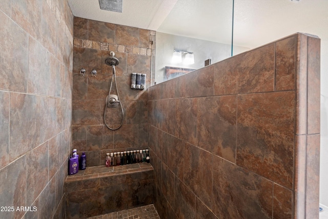 bathroom featuring a tile shower and a textured ceiling