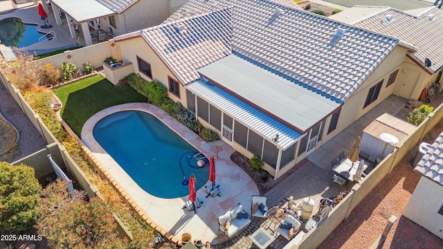 view of swimming pool with a sunroom and a patio area