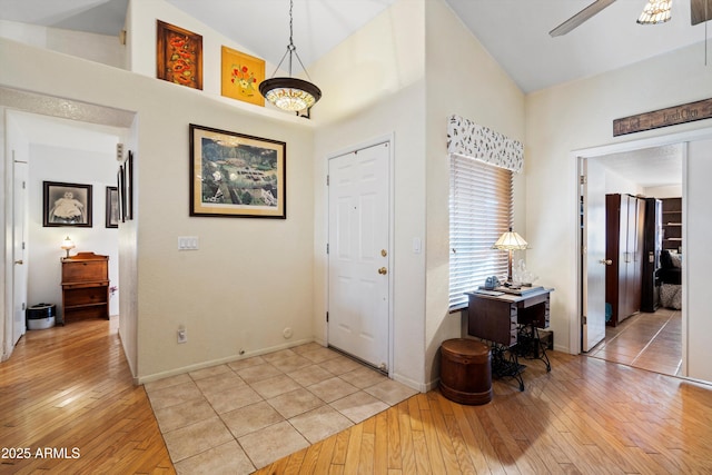 foyer entrance with lofted ceiling, light hardwood / wood-style floors, and ceiling fan